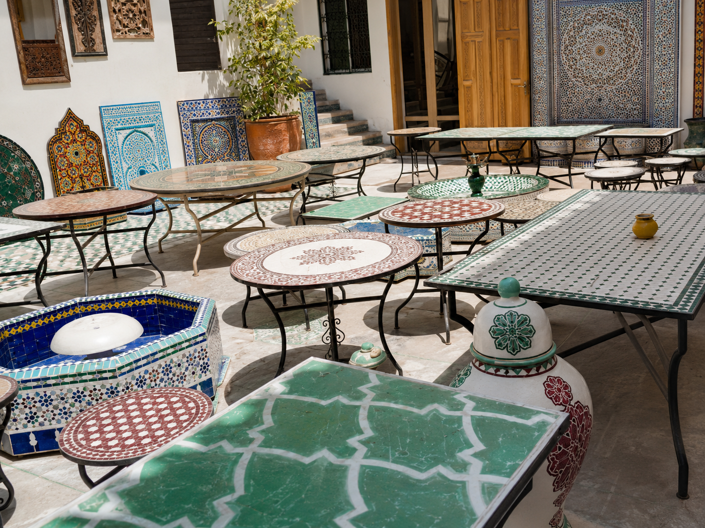 Courtyard workshop and showroom with Moroccan tables and surfaces.